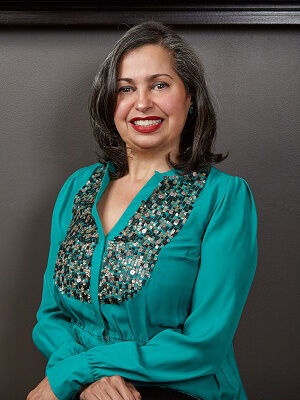 stunning woman wearing red lipstick and turquoise jeweled blouse