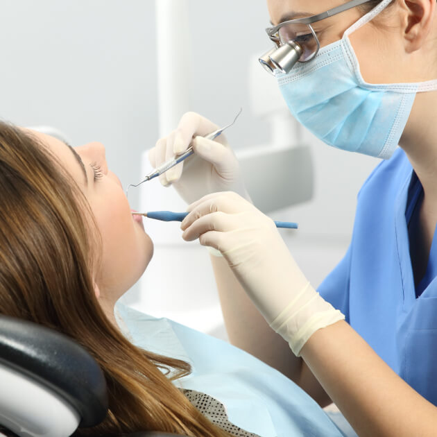 hygienist performing a dental cleaning on patient