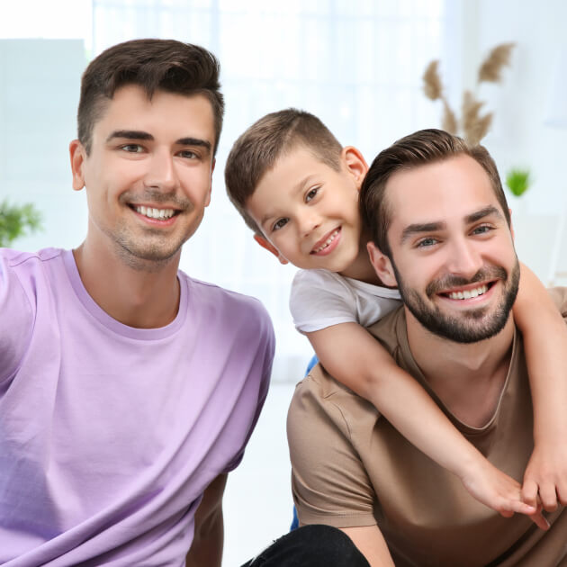 two happy men smiling with young child